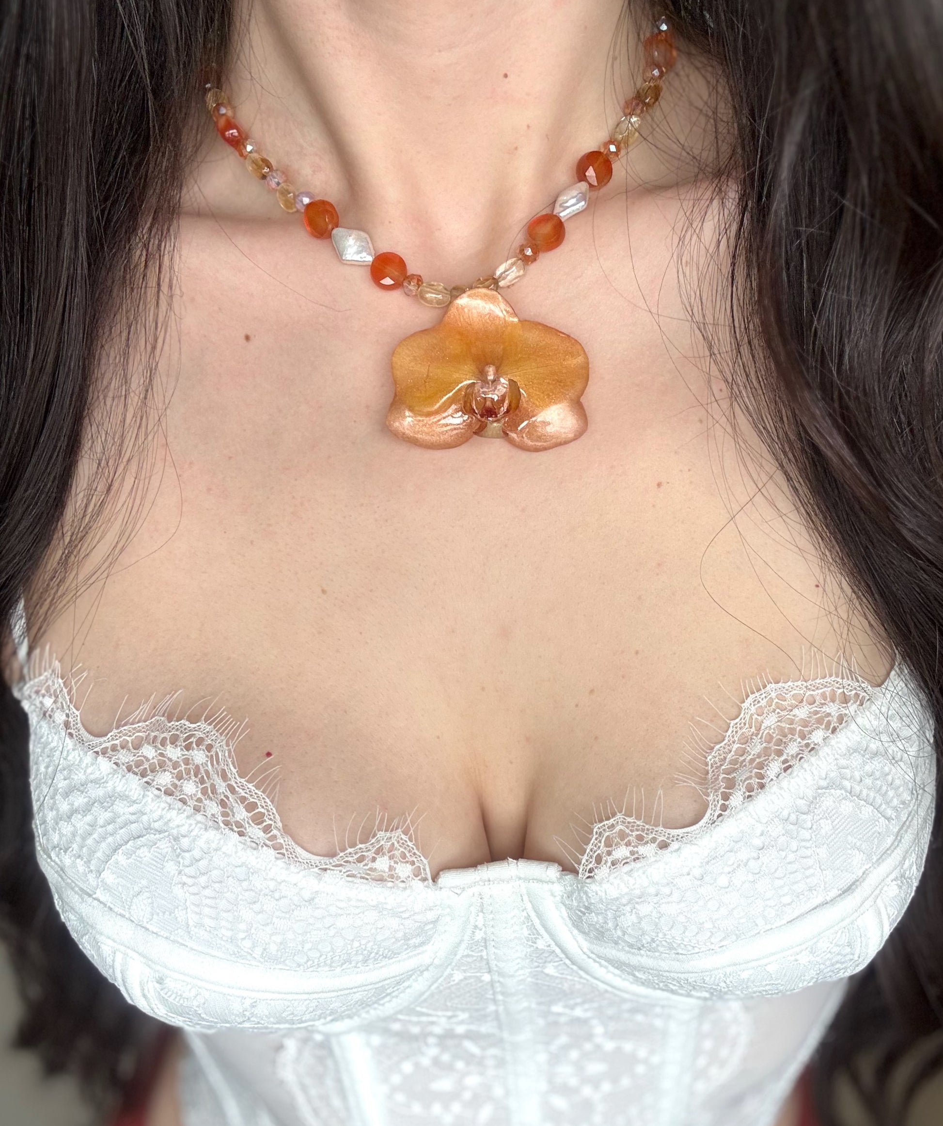 Beaded necklace with a orange orchid pendant, freshwater pearls and citrine beads.